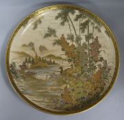 A Satsuma charger, decorated with a lake scene, birds, flowering plants and distant temple, in