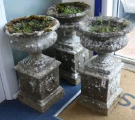 Three composition urns and pedestals, H.77cm