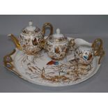 A porcelain four piece teaset, decorated with butterflies