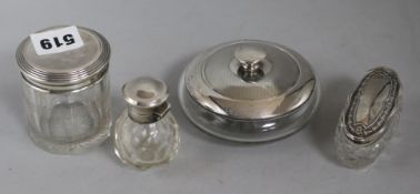 Three silver topped jars and a perfume bottle
