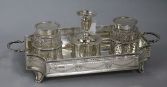 A George V pierced silver two handled inkstand, with two wells and central taperstick, William