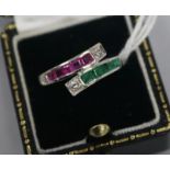 A white gold, ruby, emerald and diamond channel set crossover ring, size O.