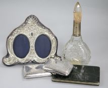 Two silver cigarette cases, a silver mounted photograph frame, a silver mounted scent bottle and