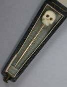 An early 20th century gold and carved ivory skull stock pin, in coffin shaped box, 6cm.