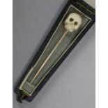 An early 20th century gold and carved ivory skull stock pin, in coffin shaped box, 6cm.