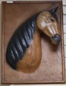 A leather and wood horse head on board