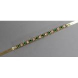 A 14ct gold, emerald and diamond small line bracelet, 15cm.