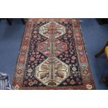 A North West Persian indigo ground rug, with figured triple octagonal pole medallion, 180cm x 135cm