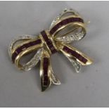 A 9ct gold ruby and diamond ribbon bow brooch, 26mm.