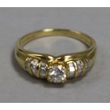 An 18ct gold and diamond ring, the central stone approx 0.25ct, flanked by baguette-set shoulders,