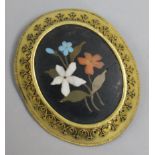 A gilt metal mounted pietra dura oval brooch with floral decoration, 46mm.