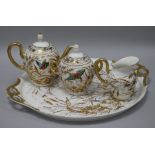 A porcelain four piece teaset, decorated with butterflies