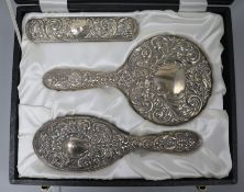 A cased 1970's repousse silver three piece dressing table set.