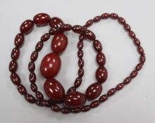 A single strand graduated simulated cherry amber bead necklace, gross 106 grams, 92cm.