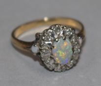 An 18ct gold, white opal and diamond set oval cluster ring, size M.