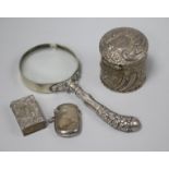 A silver handled magnifying glass, a silver trinket box, silver match box holder and silver vesta