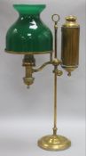 A brass student's lamp with green glass shade