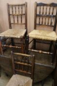Three early 19th century two-tier spindle back chairs with rush seats. An oak drop-leaf table fitted