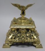 A Victorian brass inkwell with eagle mounted cover