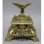 A Victorian brass inkwell with eagle mounted cover