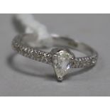 A modern 14ct white gold and pear shaped single stone diamond ring, with diamond set shoulders, size