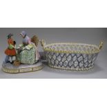 A Continental porcelain group and a faience basket