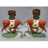 A pair of large Staffordshire pottery cow spill vases