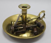 A brass candle holder and three various cork screws