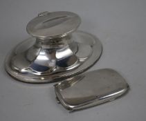 An oval silver inkwell with fluted decoration and a slim silver pendant cigarette case, the