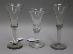 A pair of tall wine glasses, with bell bowls, on plain columns, and a wine glass with flared bowl