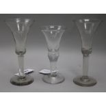 A pair of tall wine glasses, with bell bowls, on plain columns, and a wine glass with flared bowl