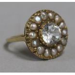 A white zircon and seed pearl cluster ring, claw-set in textured yellow metal setting