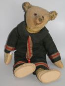 A 1920's Steiff blonde mohair teddy bear with glass eyes, Steiff ear stud, wearing a German naval