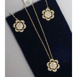 A 14ct gold and diamond flowerhead pendant on a 14ct gold fine link chain and a pair of matching