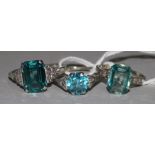 An 18ct white gold and blue zircon ring with diamond set shoulders and two other gem set rings,