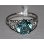 A 9ct white gold, single stone blue zircon dress ring, with diamond cluster set shoulders, size Q.