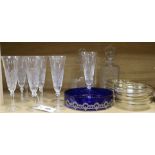 Ten cut glass champagne flutes, two decanters and a blue glass dish