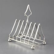 An Edwardian silver triangular seven bar toastrack, on octagonal bun feet, Mappin & Webb, Sheffield,