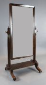 A Regency mahogany cheval mirror, with rectangular plate, on scroll feet, W.2ft 10in. H.5ft 4in.