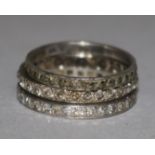 A diamond and platinum eternity ring and two other eternity rings