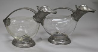 A pair of pewter mounted glass claret jugs