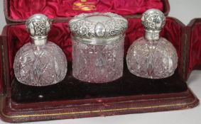 A cased late Victorian repousse silver mounted cut glass three piece toilet set by Mappin & Webb,