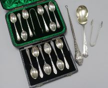 Two cased sets of six silver teaspoons, one with tongs, a silver serving spoon, silver handles