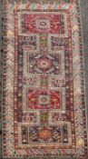 A Shirvan multi coloured rug, c.1900, with four central rectangular panels in a field of hooked