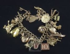 A 1960's 9ct gold charm bracelet, hung with twenty seven assorted mainly 9ct gold charms, gross 65.8