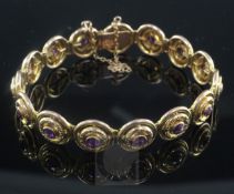 An Edwardian 9ct gold and amethyst bracelet by Murrle Bennett & Co, each of the fifteen circular