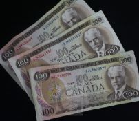 Three Canada one hundred dollar bills, Crow-Bouey, 1975, prefixes AJL,AJM & AJK.