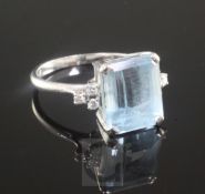 An 18ct gold, platinum and emerald cut aquamarine dress ring with diamond set shoulders, size T