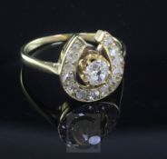 A gold and diamond set horseshoe shaped ring, the central old cut stone, surrounded by rose cut