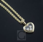 A modern 18ct gold Chopard heart shaped pendant with three "floating" diamonds, on an 18ct gold